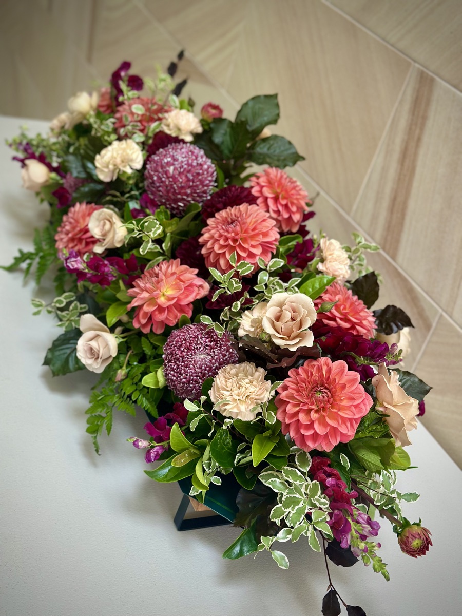 Coral dahlia and rose floral table arrangement by florist near Camden